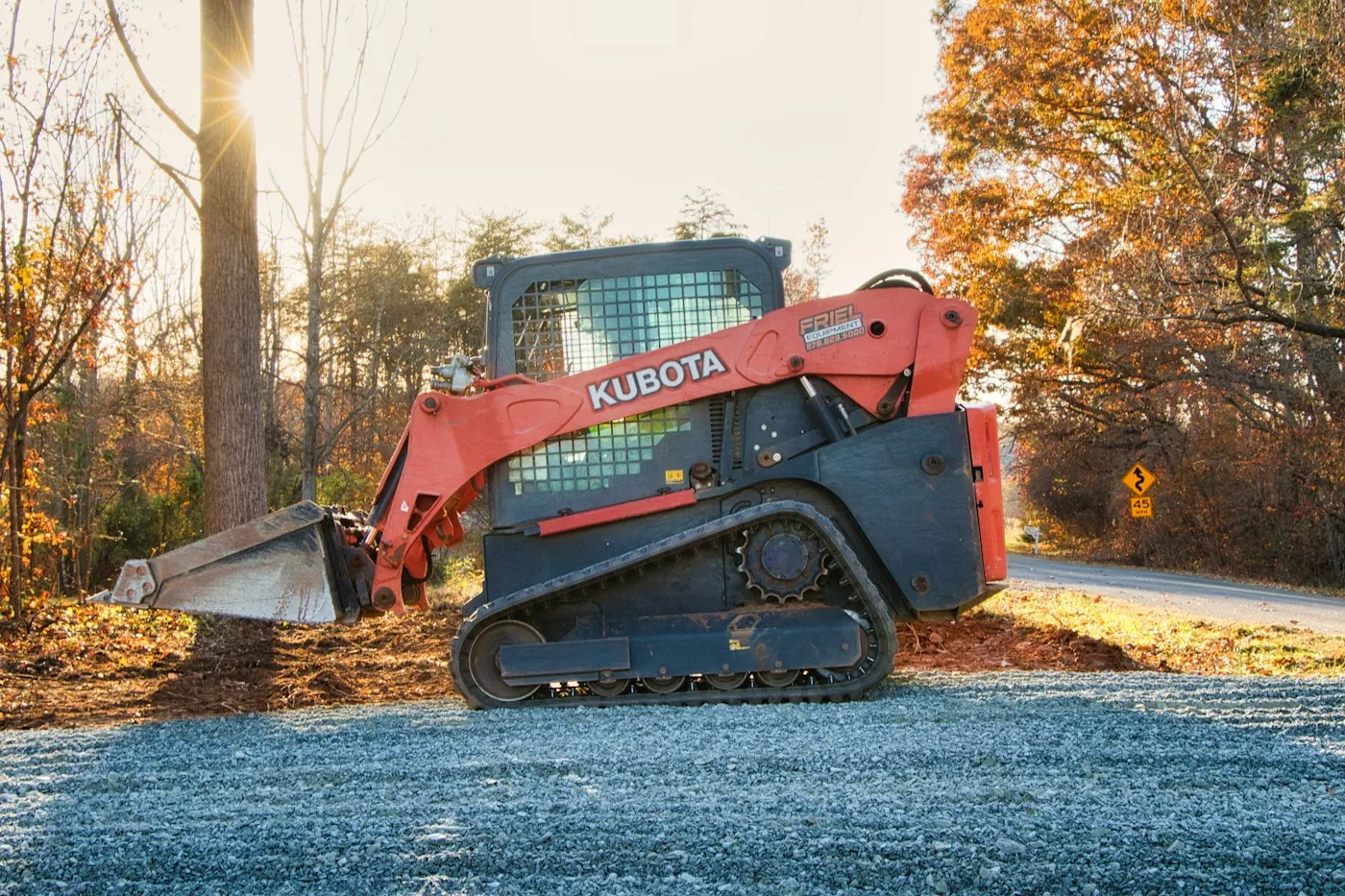 Tracked loader on a gravel surface in autumn