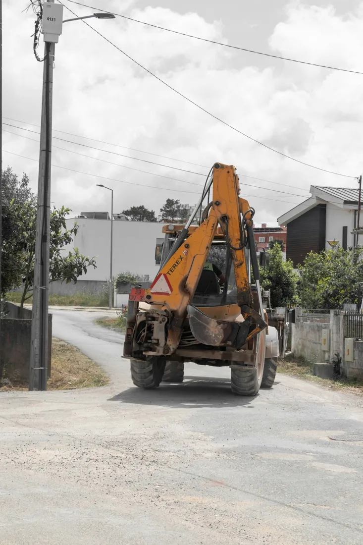 Backhoe loader traveling through an urban work area