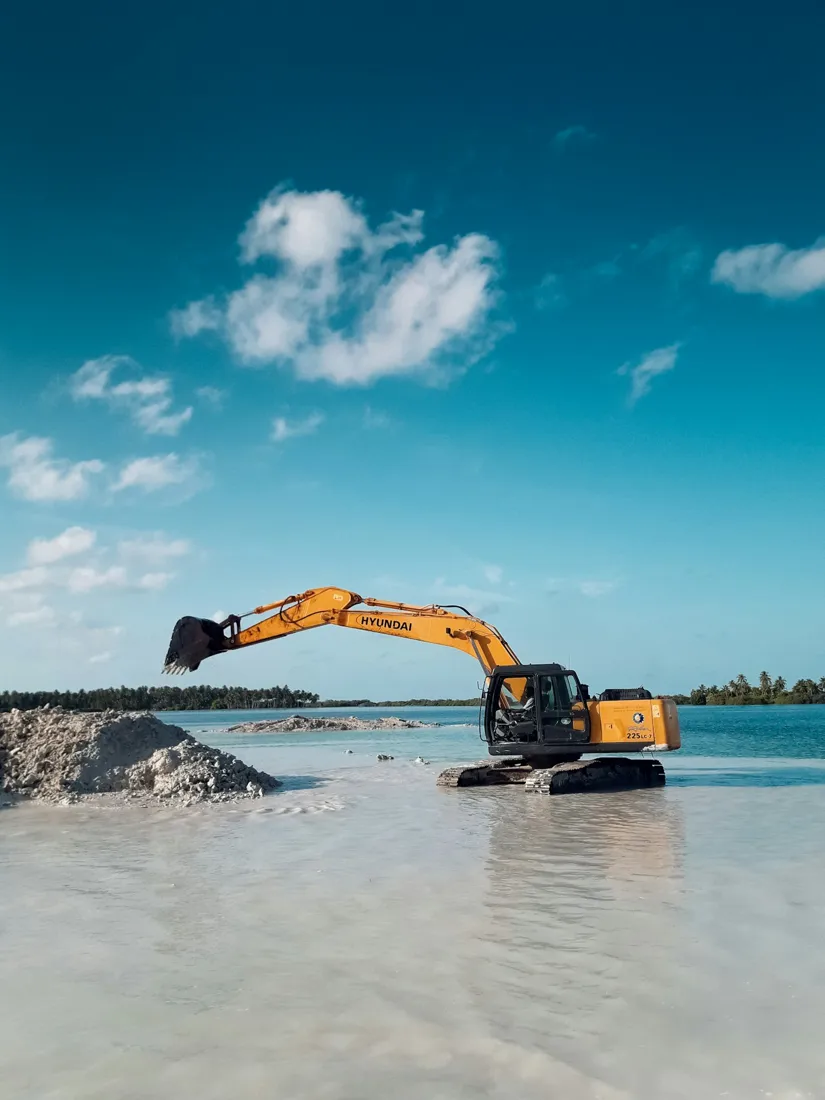 Excavator working on pale loose ground